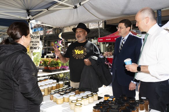 Indigenous leader Noel Pearson with federal MP Julian Leeser (centre) and state MP Matt Kean speaking to Christa from the honey stall.