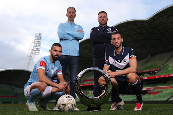 Aziz Behich of Melbourne City, Melbourne City coach, Aurelio Vidmar, Head coach of the Victory, Arthur Diles and Roderick Miranda of the Victory pose with the championship trophy.