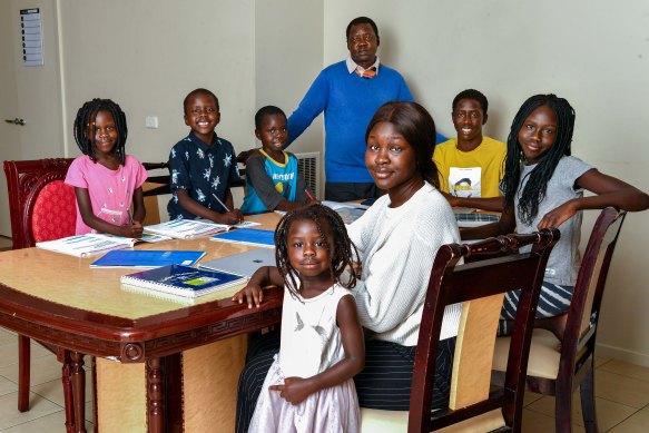 The Dhieu family (front left to right) Nyibol, 3 and  Sobur 20  (back left to right) Adut 5, Athian, 5, Makuei, 7 dad Andrew, 50, Mayen, 17 and Makuei, 7 mostly worked out of one room together during remote learning.