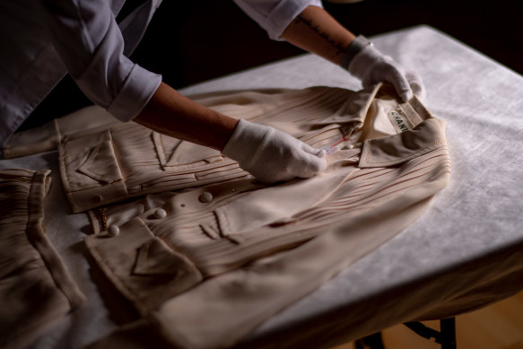 A beige jacket and skirt (Spring 1971) being prepared by textile specialist Vicki Car at the NGV.