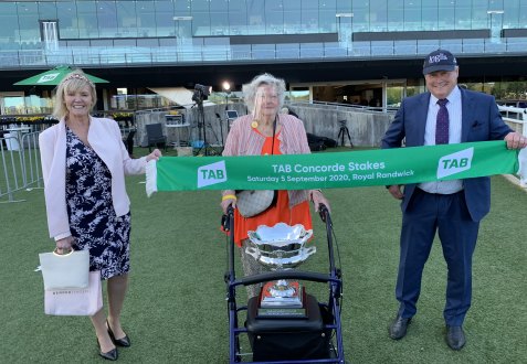 Valerie Gordon with the Concorde Stakes trophy in her walker flanked by Gytrash's trainer Gordon Richards and his wife Jacqui.