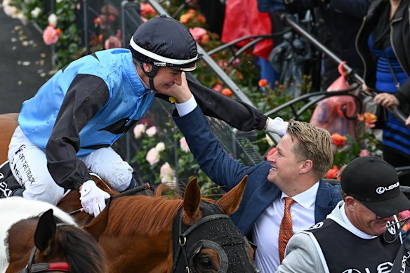 Jockey Jamie Melham and Calvin McEvoy share a moment straight after Half Yours’ Melbourne Cup win. 