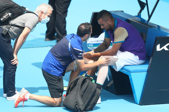 A physiotherapist assess Nick Kyrgios’ knee during a break in his match against Borna Coric of Croatia at Melbourne Park.