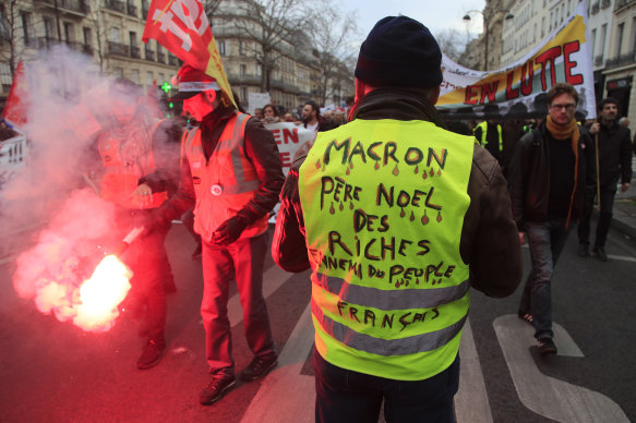 A Yellow Vest protester attends a demonstration in Paris in December. His vest says "Macron, Father Christmas to the rich, enemy of the French people". 