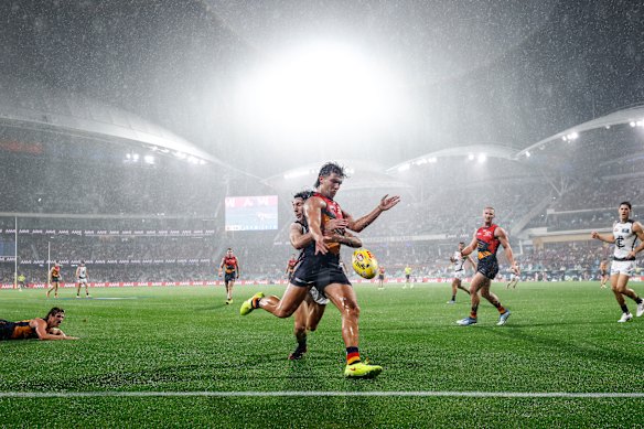 Josh Rachele gets his kick away in the driving rain.
