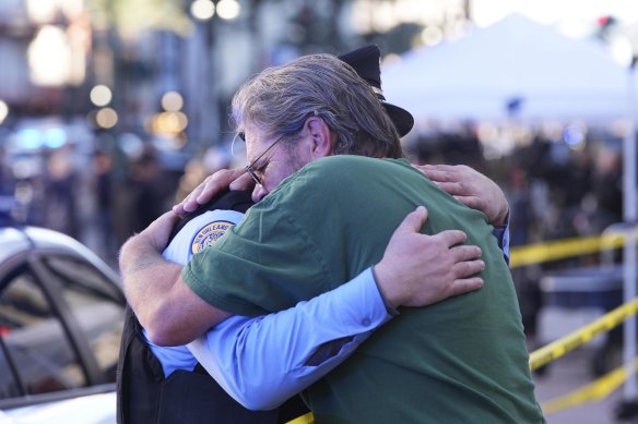 Edward Bruski, right, hugs New Orleans police officer Zachary Stevenson at the scene.