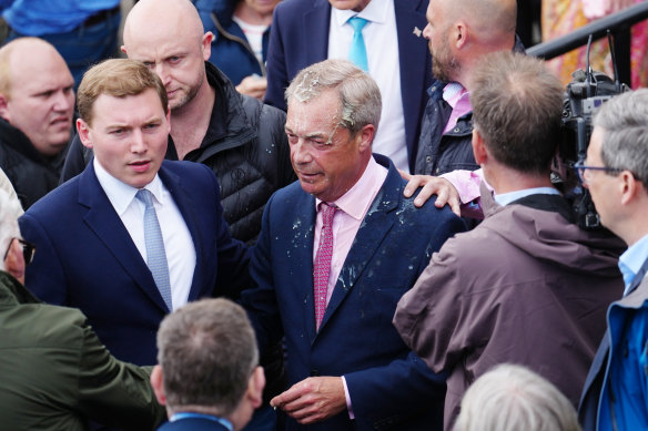Reform UK party leader Nigel Farage was drenched after a woman threw a milkshake over him on Tuesday.