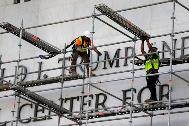 Workers prepare to take Donald Trump's name off the Kennedy Centre.