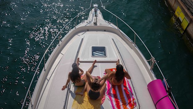 People sit on a boat as it enters Diversey Harbor on a hot and humid Tuesday, in Chicago.