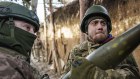 Ukrainian soldiers load ammunition into a self-propelled howitzer on the frontline in Donetsk.