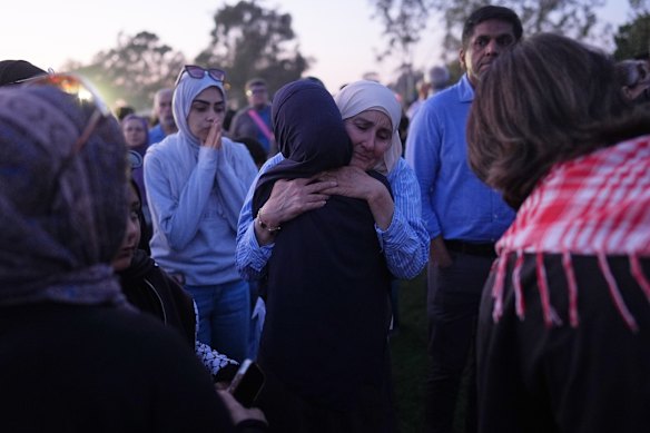 Attendees embrace during a vigil, the day after a shooting, outside the Islamic Center in San Diego. 