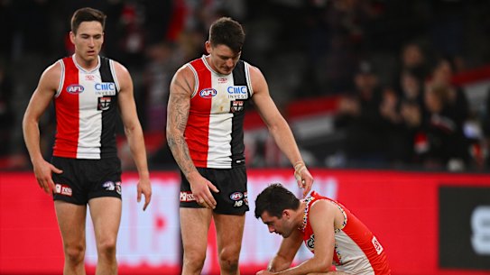 Josh Battle of the Saints consoles Logan McDonald of the Swans.