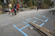 Residents walk along a damaged road in Alegria, Cebu province on Wednesday.