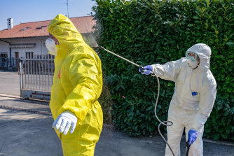 A worker is decontaminated near Bergamo in Italy.