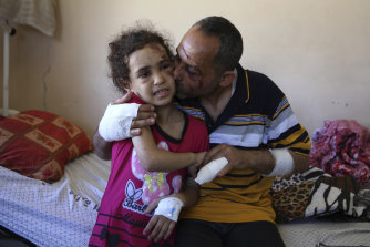  Riad Ishkontana, 42, embraceing his seven-year-old daughter Suzy, the only one of his children to survive the air strike that hit the family’s building in May. At least 256 Palestinians, including 66 children, were killed during the fighting. In Israel, 13 were killed, including two children. 
