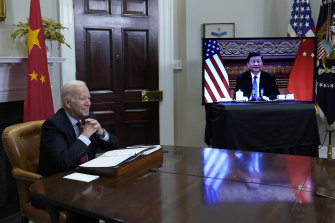 President Joe Biden, left, speaks as he meets virtually with Chinese President Xi Jinping, on screen, from the Roosevelt Room of the White House in Washington on Monday, US time.