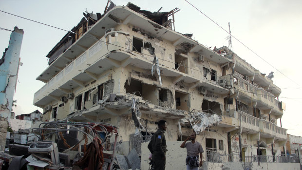 Somali soldiers stand guard at a destroyed building in Mogadishu, Somalia, where terror group al-Shabab has picked up.