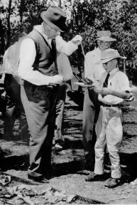 John Bridle, 12, receives a steak from the British Prime Minister at a barbecue yesterday at Banyak Suka, the Queensland property of his parents.