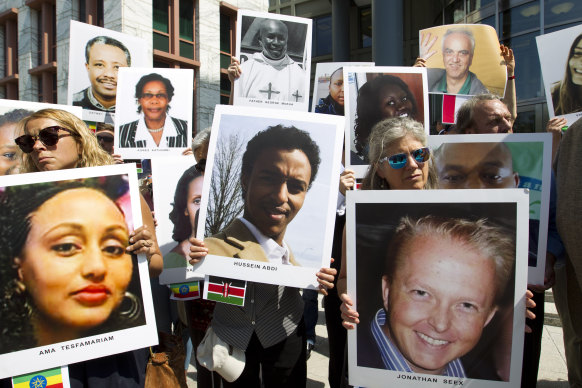 Demonstrators in Washington hold pictures of victims of the Boeing 737 Max 8 which crashed in Ethiopia in March last year, killing 157 people.