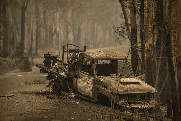 A firefighting Landcruiser lies burnt in Kangaroo Valley. It crashed after hitting a fallen tree on Saturday. 