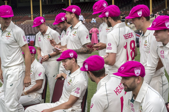 Tim Paine and other Australian players pose in pink caps ahead of the third Test in Sydney.