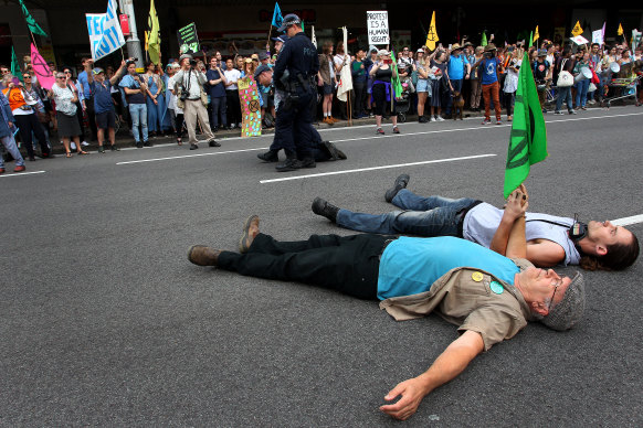 A man is arrested by police as activists lay in the road during an Extinction Rebellion protest in Sydney in 2019.
