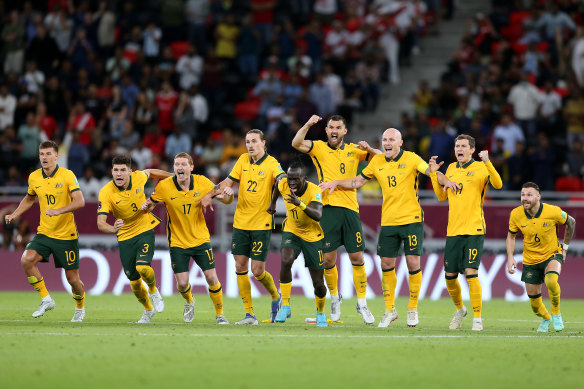 Andrew Redmayne’s Socceroos teammates celebrate after the keeper’s crucial save in Doha.