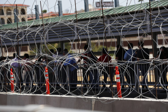 Migrants line up to cross the border into Texas from Nuevo Laredo, Mexico. 