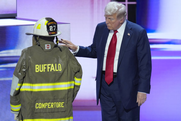 Republican presidential candidate former President Donald Trump standing next to a uniform bearing the name Compertore.