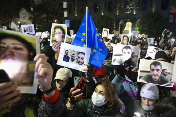 Demonstrators hold portraits of activists injured during protests as they take part in an anti-government rally outside the Parliament building in Tbilisi, Georgia.