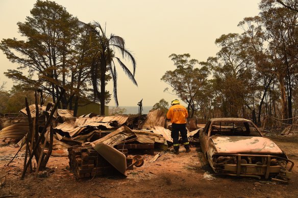 A firefighter inspects a destroyed home at Balmoral, south of Sydney, on Friday.