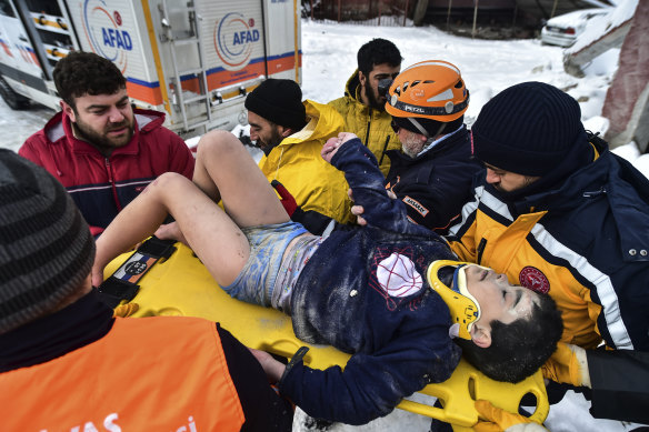 Rescue workers and medics carry a survivor, eight-year-old boy Arda Gul, from the debris of a collapsed building in Elbistan, Kahramanmaras, in southern Turkey.