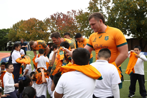 Angus Bell and Jake Gordon hand out gifts to the students of St Johns Primary, Auburn.