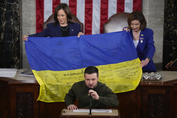 US Vice President Kamala Harris and then-House Speaker Nancy Pelosi, right, after being presented with a Ukrainian flag by President Volodymyr Zelensky. The flag was signed by front-line troops in Bakhmut.
