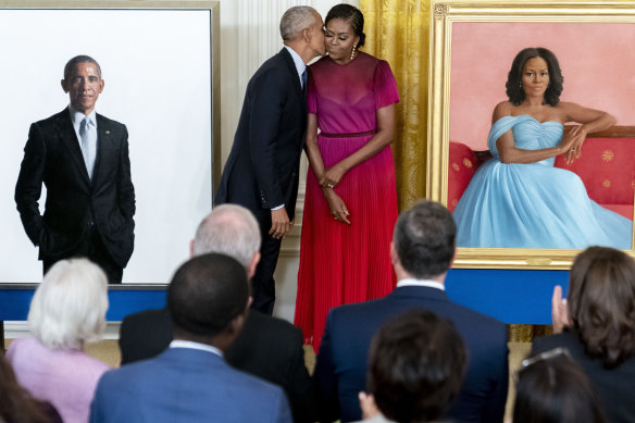 Former president Barack Obama kisses his wife former first lady Michelle Obama after they unveiled their official White House portraits during a ceremony in the East Room of the White House in Washington. 