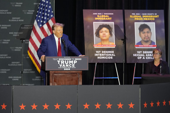 Republican presidential nominee former president Donald Trump speaks in front of pictures of undocumented immigrants who committed violent crimes.