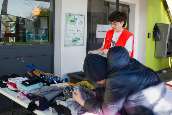 Alexandra, who fled across the border from Ukraine to Poland, looks through clothing supplied by the Red Cross while waiting at Tourcoing, France. 