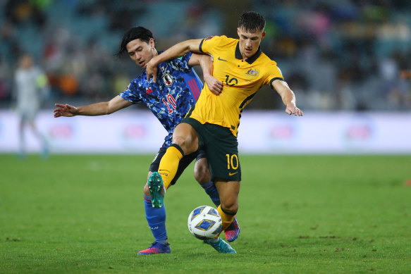 Takumi Minamino of Japan and Ajdin Hrustic compete for the ball.