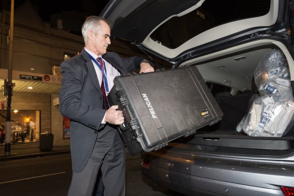 An AFP officer removes shredded documents and other evidence from the AWU offices in Sydney in 2017. 