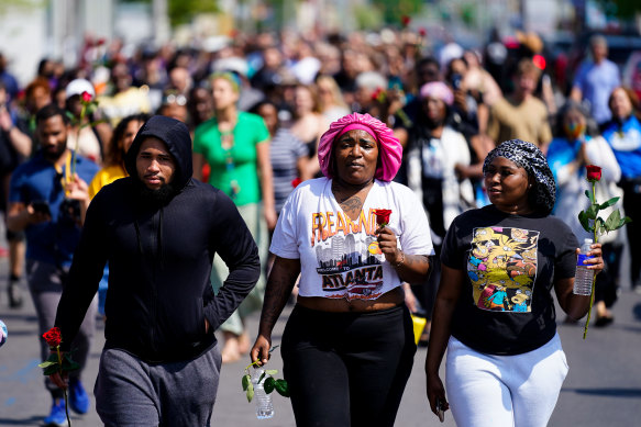 People march to the scene of a mass shooting at a supermarket in Buffalo.