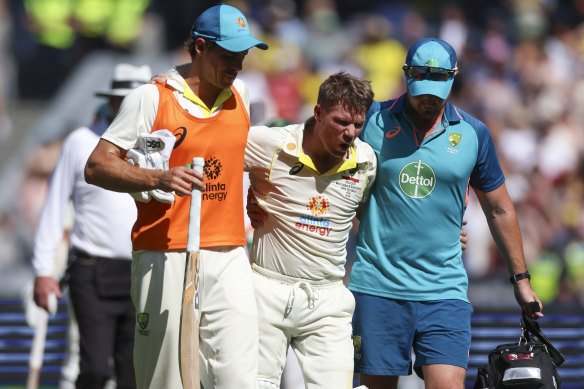 An exhausted and cramping Warner had to be helped from the field after reaching his double century.