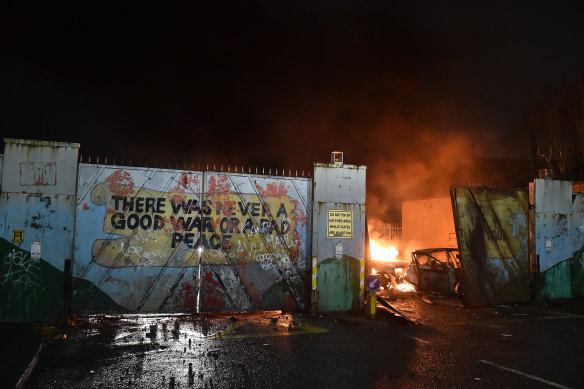 Cars burn after Nationalists and Loyalists rioted against one another at the “peace wall” interface gates which divide the two communities in Belfast.