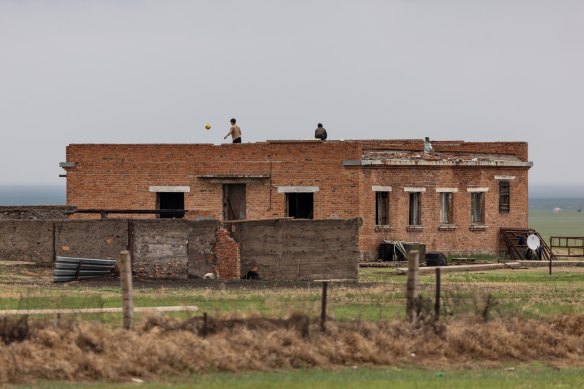 Children play football at an abandoned Russian airbase in Mongolia. 