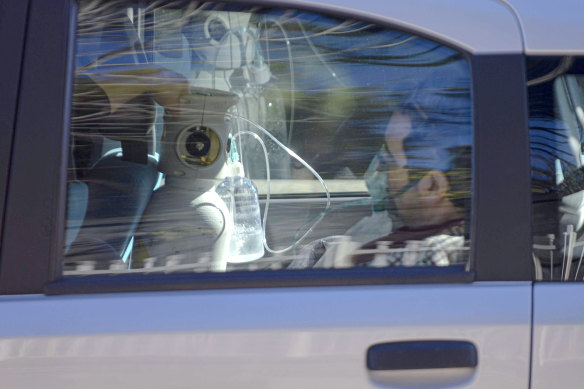 A man is given oxygen in a car parked outside a hospital in Naples.