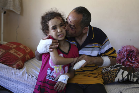 Riad Ishkontana, 42, embraces his seven-year-old daughter Suzy, the only one of his children to survive the air strike that hit his building on Sunday. 
