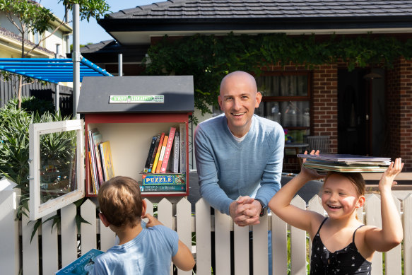 Adrian Perillo-Phipps and his children Thomas and Alice have a street library in their front yard to share books with their community. 