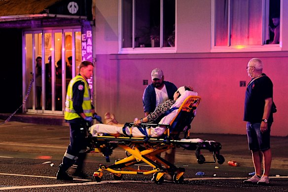 A woman is transported to an ambulance.