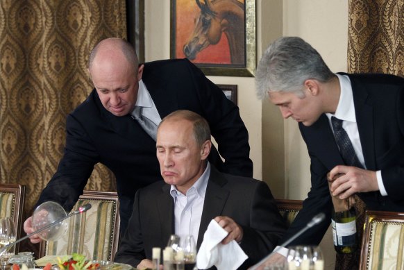 “Putin’s chef”: Yevgeny Prigozhin, left, serves food to Russian Prime Minister Vladimir Putin during a banquet in 2011.