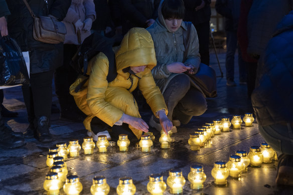 In Lvic, people light candles as they hold a vigil for those killed in Bucha.