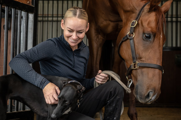 Kathy O’Hara shares some time  between Big Red and Daisy, the whippet, in the stables at her farm.